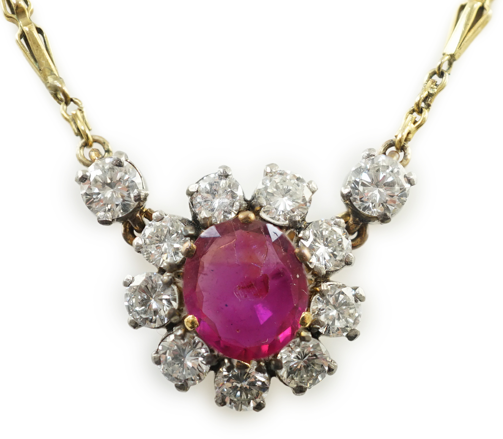 A modern 9ct gold, single stone oval cut ruby and eleven stone round cut diamond cluster set pendant necklace